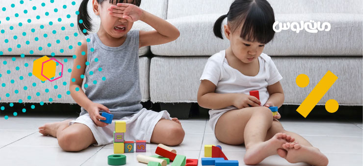 دو دختر بچه گریان در حال بازی با مکعب های رنگی