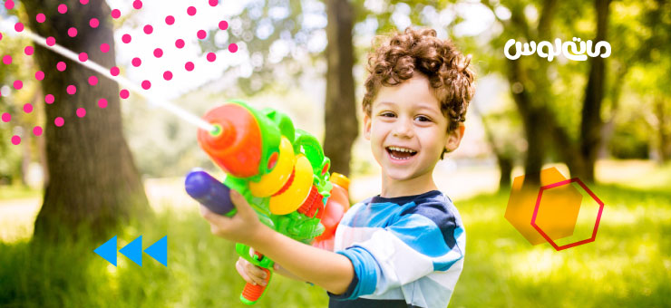 کودک خردسال در حال بازی با تفنگ آب پاش بزرگ سبز