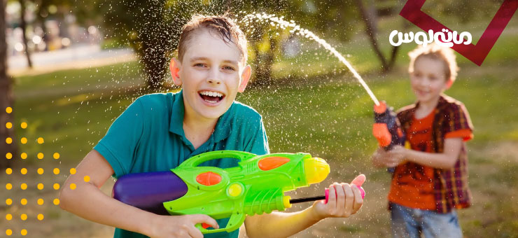 دو پسر بچه در حال بازی با تفنگ های بزرگ اب پاش
