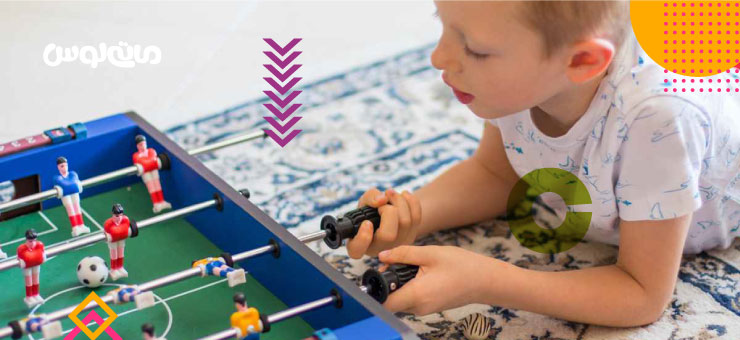 کودک خردسال در حال بازی با فوتبال دستی