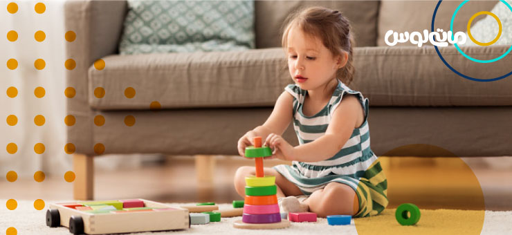 بازی کودک یک ساله با حلقه های رنگی برج