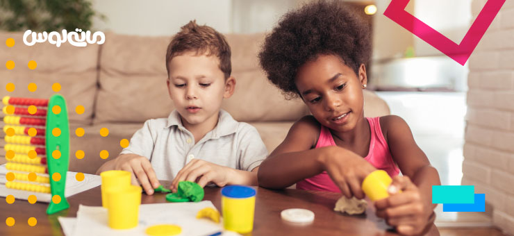 دختر بچه و پسر بچه در حال ساختن با خمیر بازی