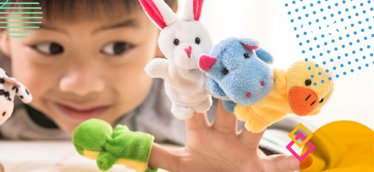 پسر بچه خندان با پاپت های کوچک حیوانات رنگی در انگشتان