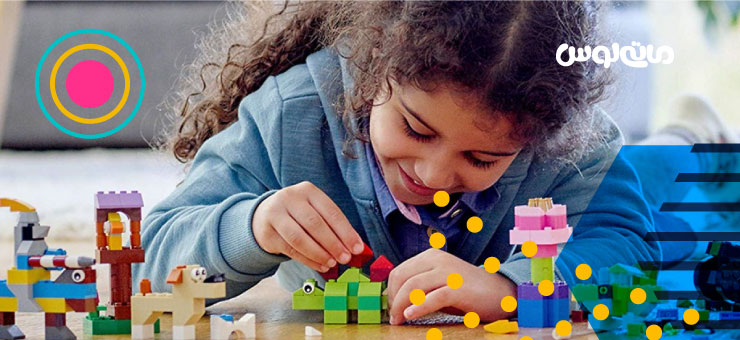 دختر بچه خردیال در خال بازی با اجرک های لگو رنگی