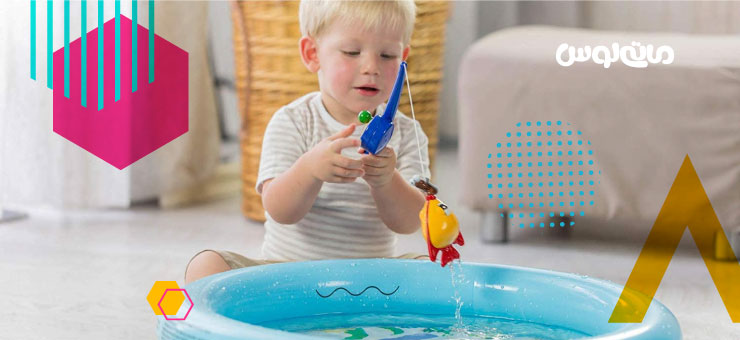 کودک دو ساله در حال بازی با قلاب ماهی گیری اسباب بازی