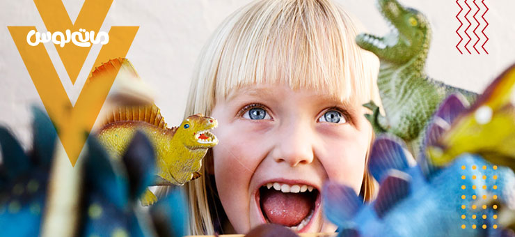 کودک هیجان زده هنگام بازی با فیگور های دایناسور