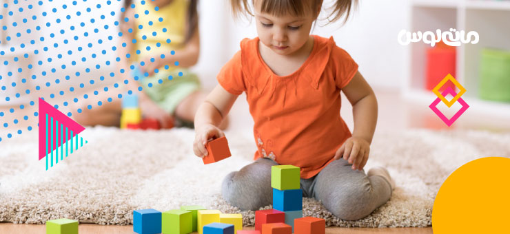 کودک خجالتی در حال چیدن مکعب های رنگی روی هم