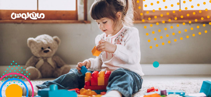 دختر بچه در حال بازی با لگو قرمز رنگ