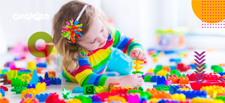 دختر بچه در میان تعداد زیادی لگوی رنگی