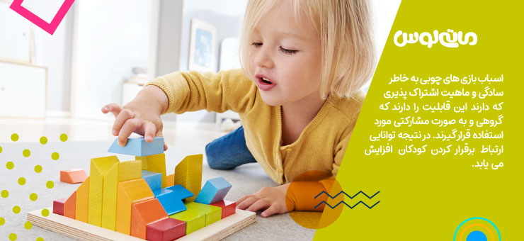 دختر بچه در حال چیدن مکعب های چوبی روی هم