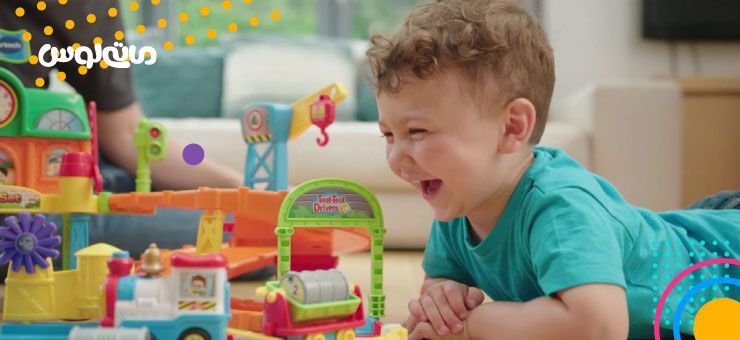 خوشحالی کودک از بازی با قطار رنگی اسباب بازی