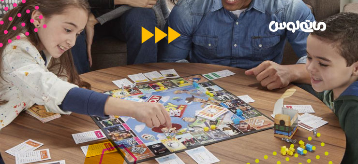 کودکان دبستانی در حال بازی با مونوپولی در کنار خانواده