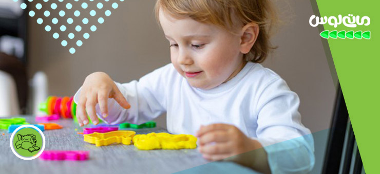 دختر بچه در حال بازی با قالب خمیربازی