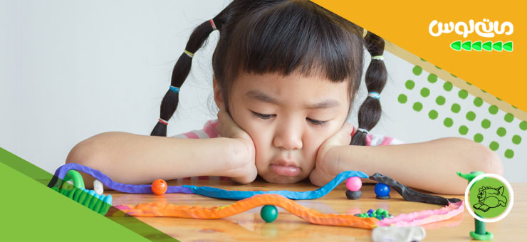 دختربچه با نارضایتی به اسباب بازی اش نگاه می کند