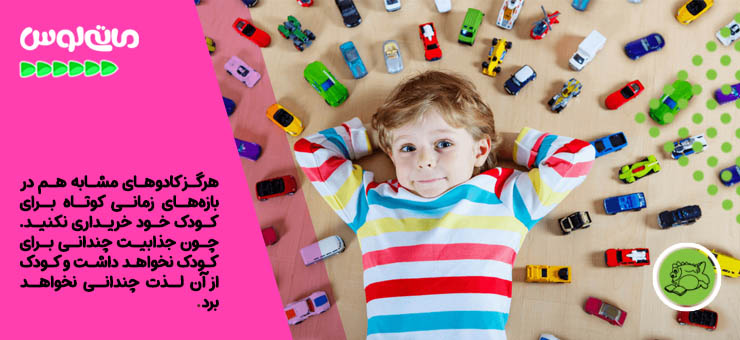 پسر بچه در کنار ماشین های اسباب بازی دراز کشیده